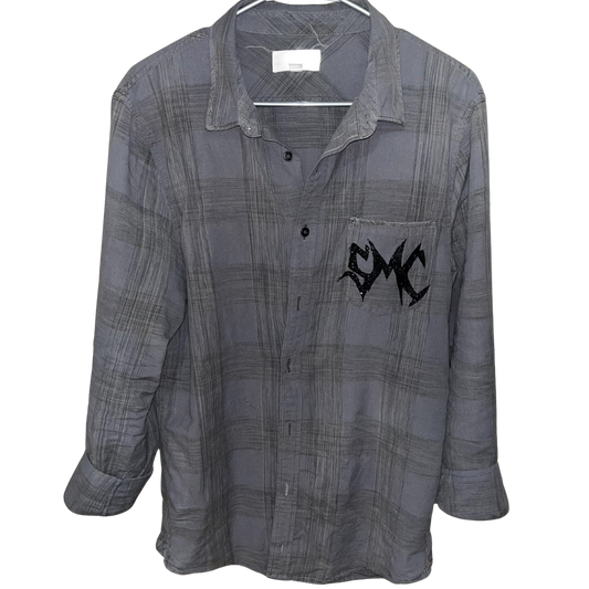 A one-of-a-kind grey plaid button-up shirt titled “Grey Matter”, featuring the signature black glitter SMC sigil on the chest pocket. Hand-altered and part of Sam Silvain’s Secret Mystic Collection.